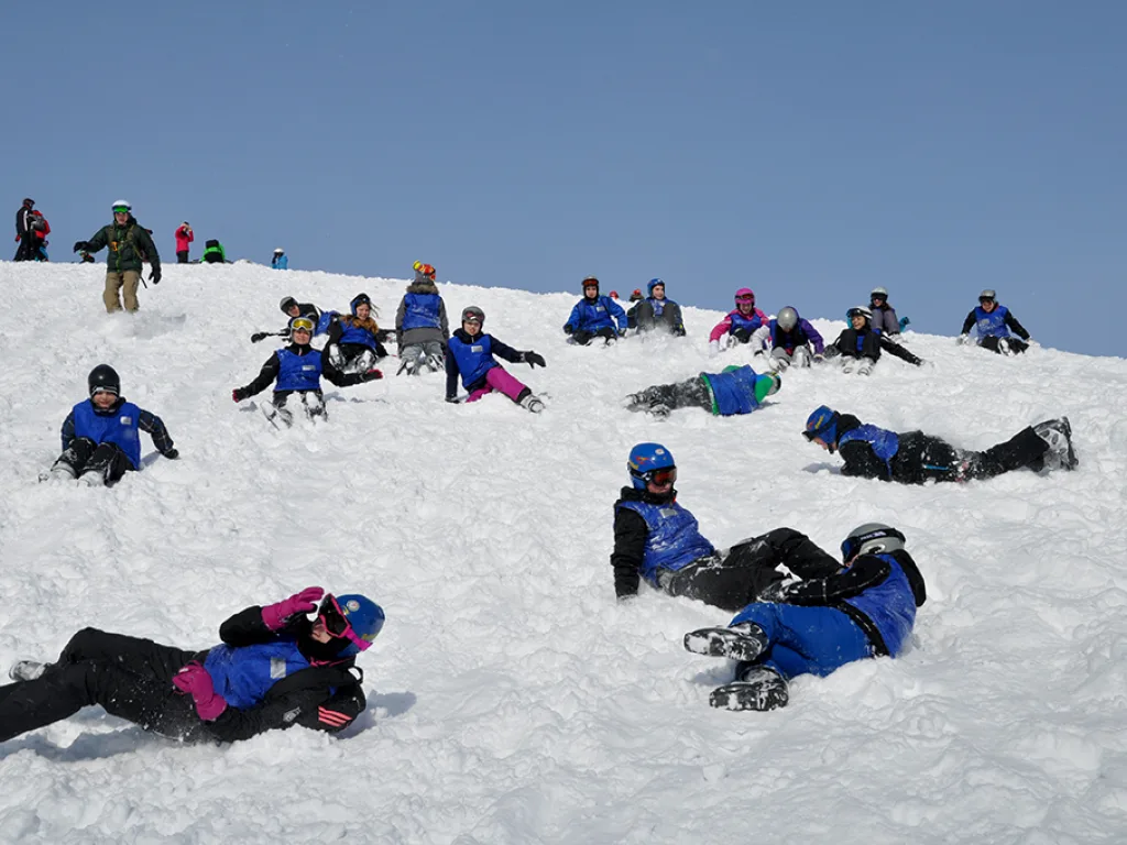 Gruppe tobt im Schnee auf der Kuppe.